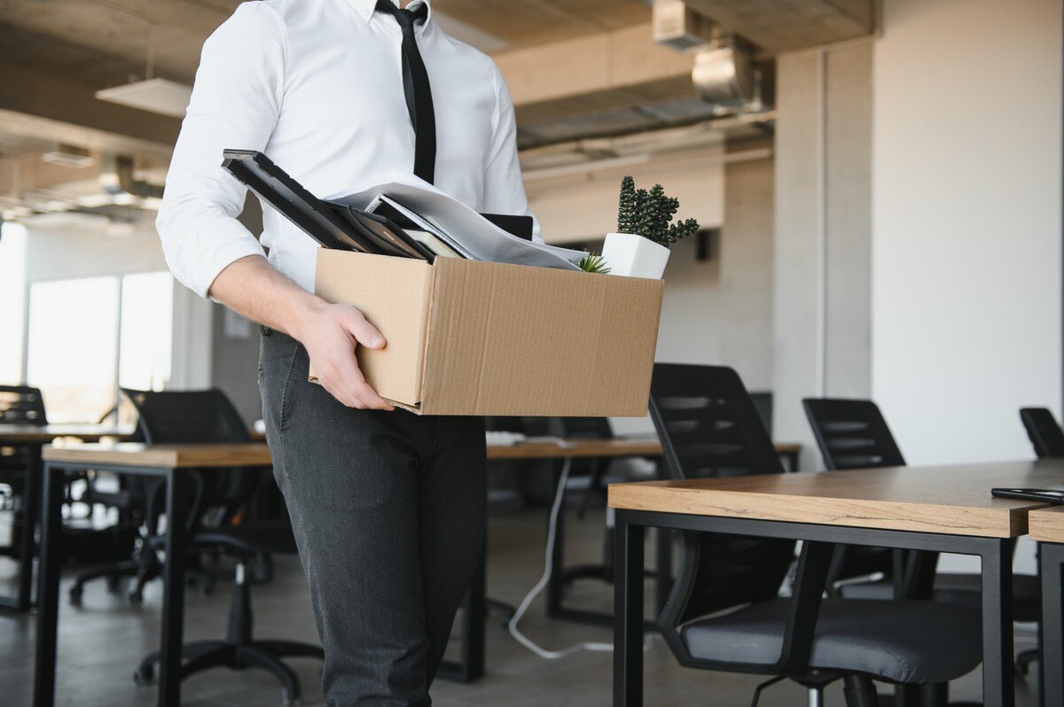 Employee packs a box of his things after submitting resignation.