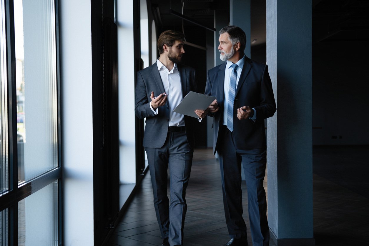 Two business leaders walking down hallway