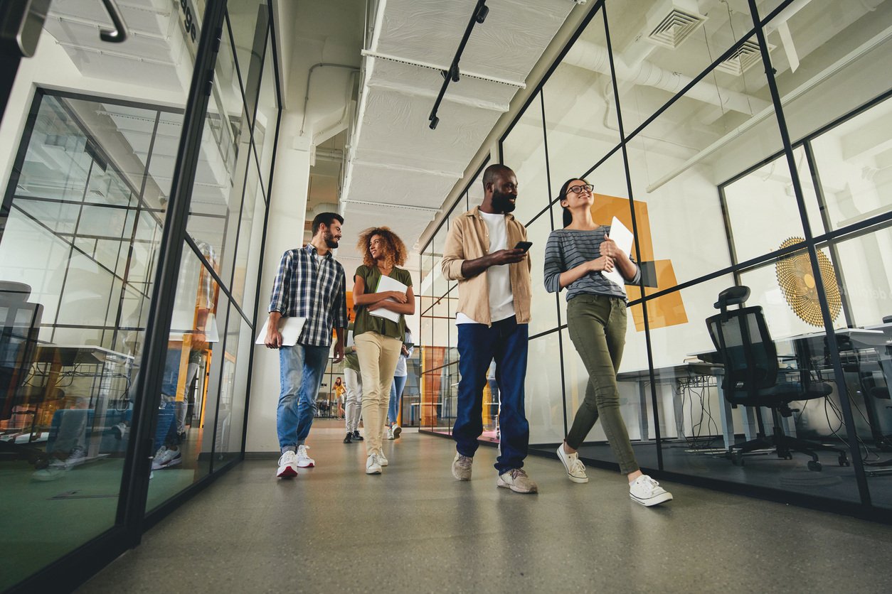 Employees walking down hallway of office