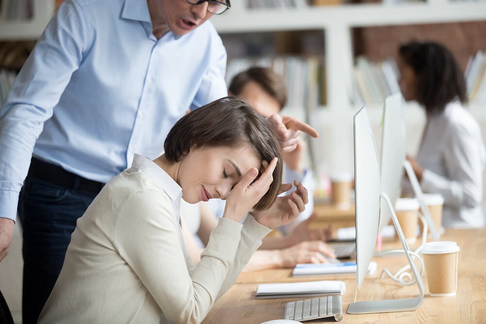 Overwhelmed employee getting yelled at by her boss